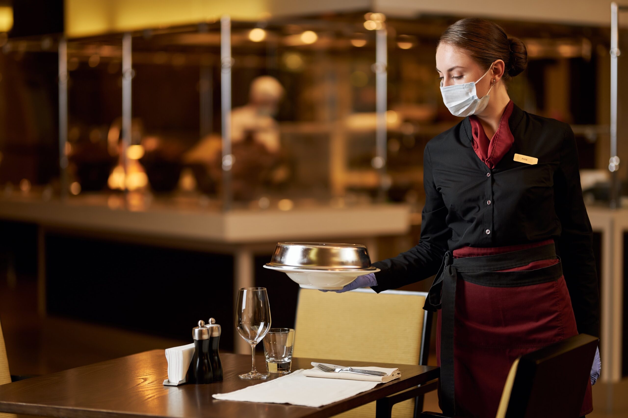 serious-young-woman-in-mask-working-at-restaurant-2023-11-27-05-36-21-utc-min